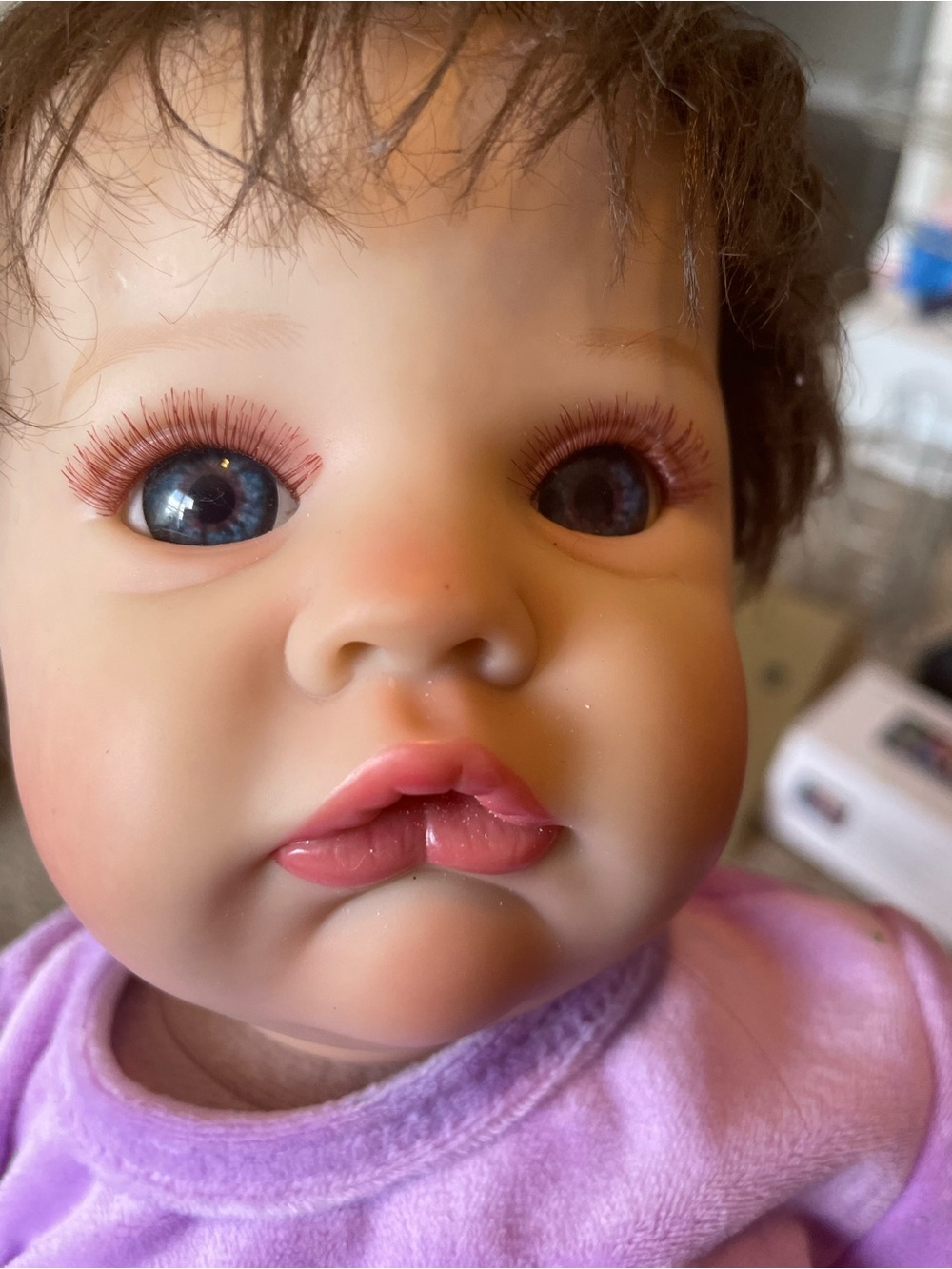 Realistic Baby Doll with Blue Eyes and  purple  outfit